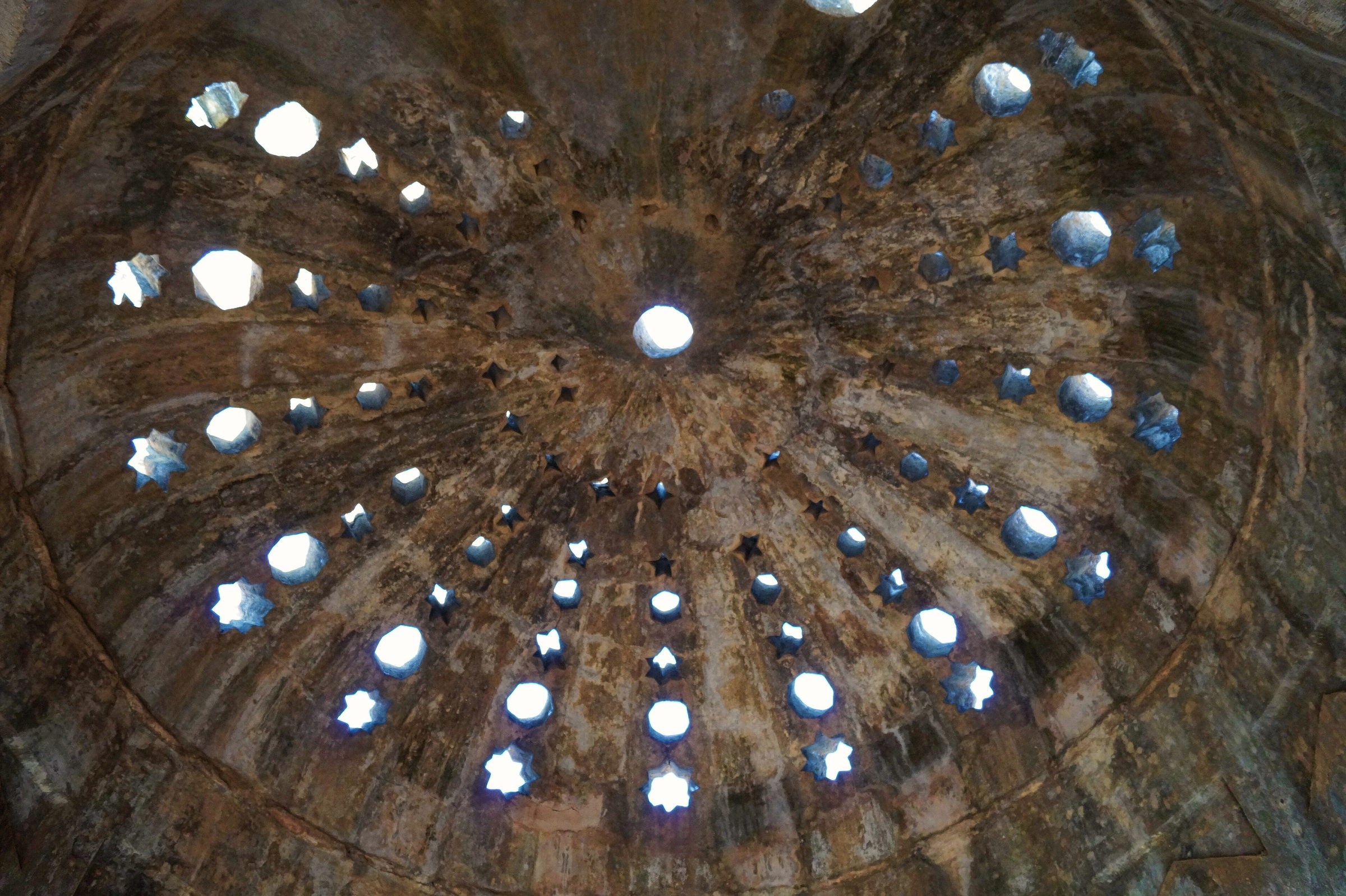 Hammam dome pierced with star-shaped apertures, daylight falling into the chamber