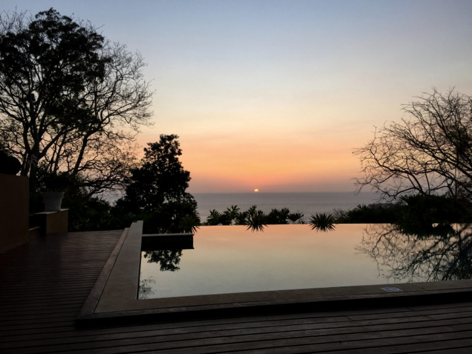 Infinity pool at dusk with the water meeting a low horizon