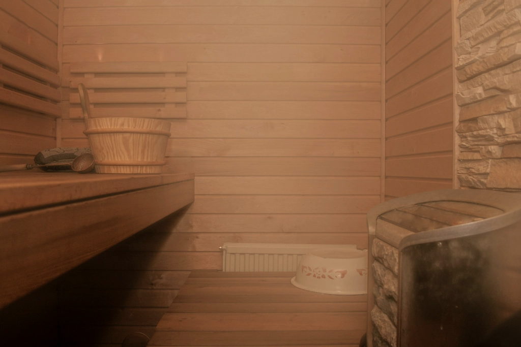 Pale sauna bench above a stone-filled heater